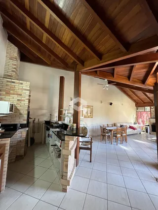 Interior de uma sala de estar com teto de madeira e piso cerâmico.