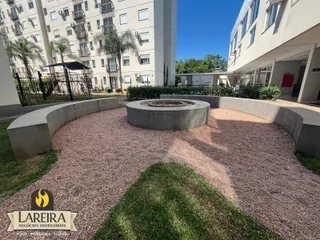 Área externa com paisagismo e elementos de concreto no condomínio.