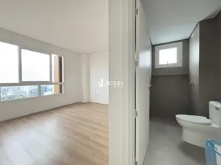 A sala de estar possui uma grande janela com vista para a paisagem urbana.
