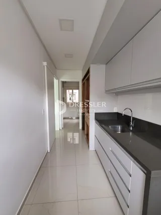 Corredor interno de uma residência branca com piso de cerâmica.