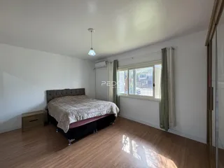 Quarto com cama e janela em ambiente interno.