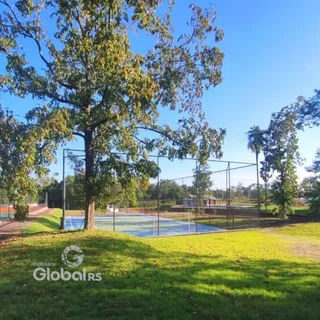 Vista externa de um terreno com gramado e cerca de fundo.