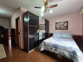Quarto com cama e guarda-roupa em ambiente interno.