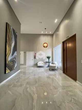 Hall de entrada com piso de mármore claro e decoração moderna.