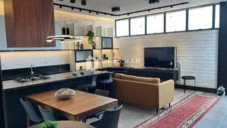 Sala de estar com cozinha e área de jantar em um apartamento.