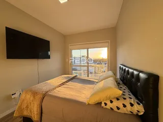 Quarto com cama e televisão em um apartamento.