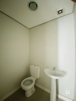 Foto de um banheiro interno com vaso sanitário e pia.