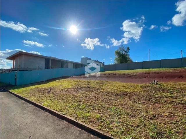 Vista externa do terreno com grama e cerca de limite.