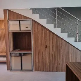 Parede revestida em madeira com escadaria moderna em um ambiente interno.
