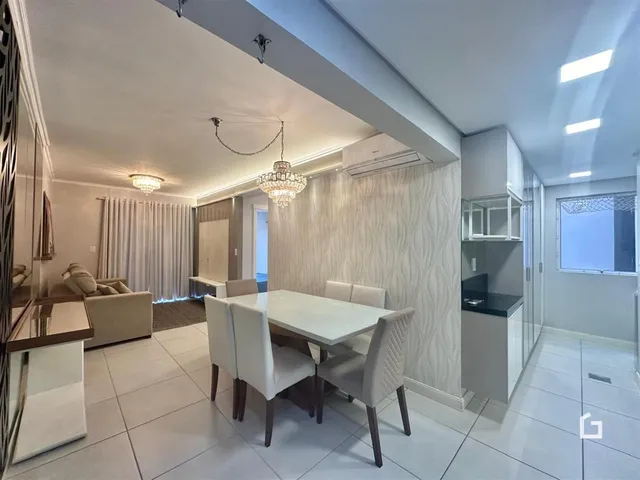 Sala de estar e jantar com paredes brancas e piso claro.