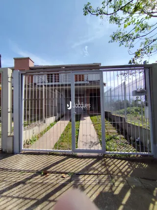 Vista da fachada de uma propriedade com portão de metal.