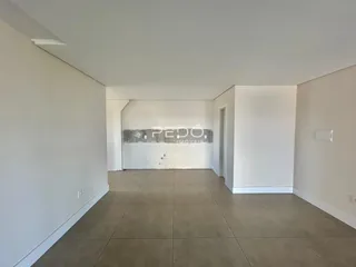 Um corredor interno com paredes brancas e piso de cerâmica.