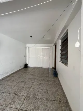 Corredor interno com piso de cerâmica e paredes brancas.