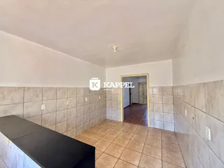 Corredor com revestimento de azulejos e passagem para outro ambiente.