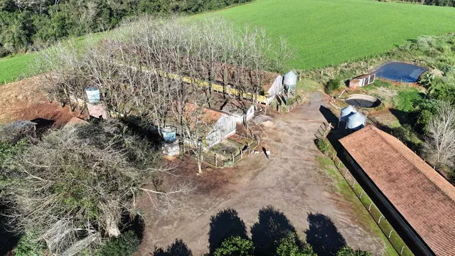 Vista aérea de uma propriedade rural com área de campo ao redor.