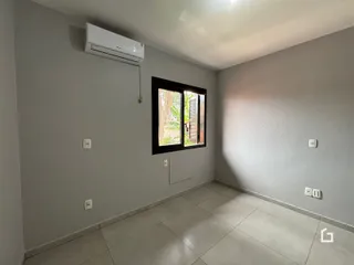 Interior de uma sala com parede cinza e piso de cerâmica.