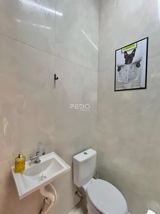 Foto de um banheiro com pia e vaso sanitário revestidos.