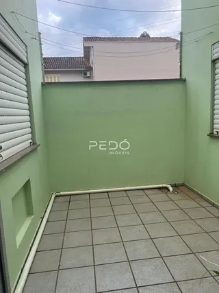 Vista da fachada de uma propriedade em Lajeado, Brasil, mostrando uma parede verde e um piso de cerâmica.