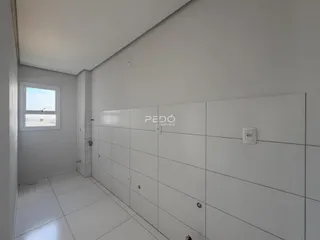 Corredor interno com piso claro e paredes brancas.