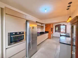 Uma cozinha moderna com armários brancos e eletrodomésticos de aço inoxidável.