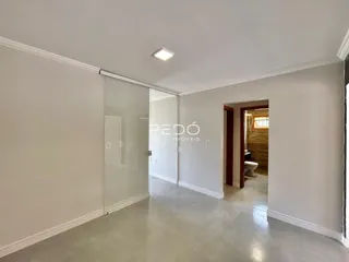 Hall da propriedade com paredes brancas e piso claro.