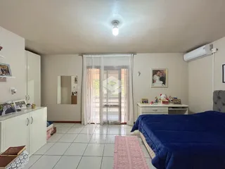 Quarto espaçoso com piso de cerâmica e janela de vidro.