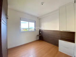 Ambiente interno de uma sala com piso de madeira e janela.