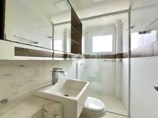 Foto de um banheiro moderno com revestimento de mármore e box de vidro.