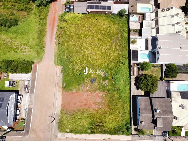Vista aérea de um lote com grama alta e uma estrada adjacente.