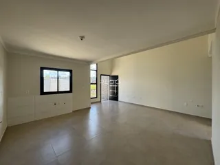 Ambiente interno de uma sala ampla com piso de cerâmica em Lajeado, Brasil.