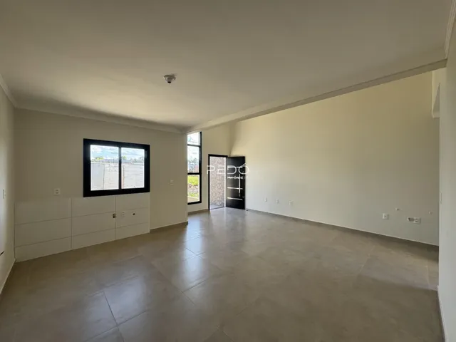 Ambiente interno de uma sala ampla com piso de cerâmica em Lajeado, Brasil.