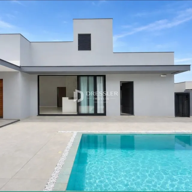 Fachada moderna de uma residência com piscina no exterior.