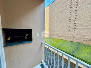 Fachada de um prédio em Lajeado, Brasil, mostrando paredes de alvenaria e uma grade de janelas.