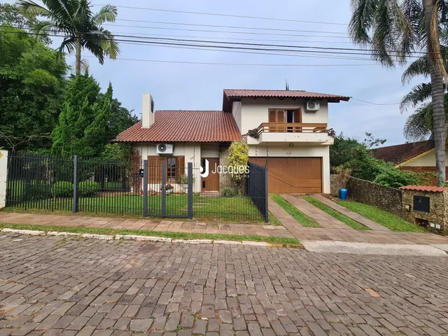 Fachada de uma casa em Lajeado, Brasil, com cerca e garagem.
