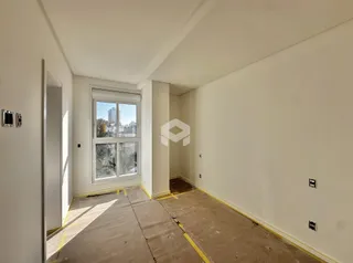 Interior de uma sala com piso de concreto aparente e janela para a cidade.