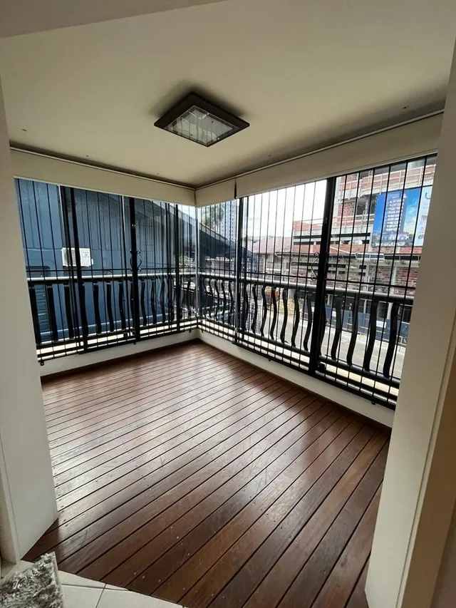 Vista de um ambiente com piso de madeira e sacada.