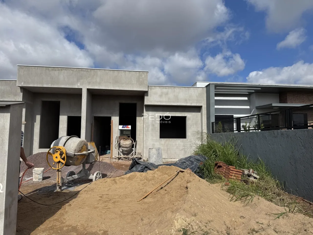 Fachada de uma construção em Lajeado, Brasil, com terra exposta na frente.