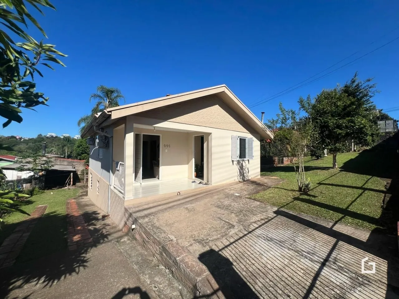 Fachada externa de uma casa em Lajeado, Brasil, com jardim e entrada de concreto.