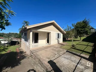 Fachada externa de uma casa em Lajeado, Brasil, com jardim e entrada de concreto.