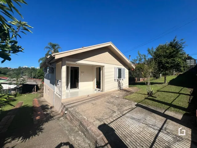 Fachada externa de uma casa em Lajeado, Brasil, com jardim e entrada de concreto.