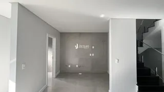 Hall de entrada com paredes cinzas e porta de acesso.