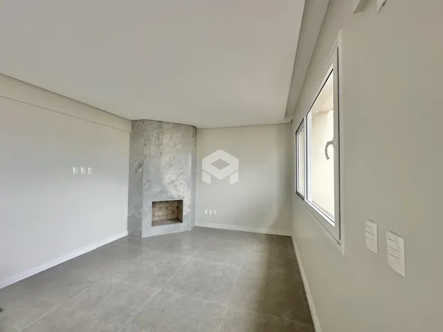 Uma sala de estar com paredes brancas e piso claro.