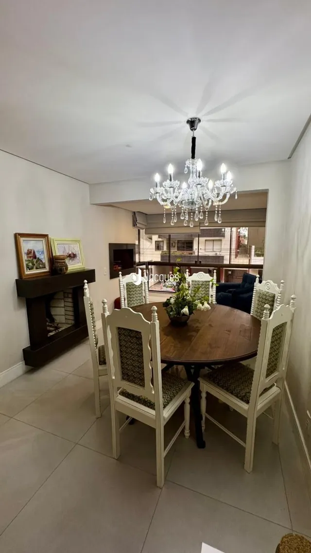 Sala de jantar com mesa de madeira e lareira em um imóvel no Brasil.