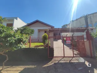 Fachada de uma residência em Lajeado, Brasil com cerca e portão de ferro.