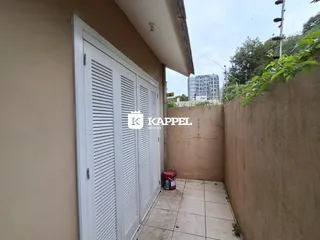Foto da fachada de um imóvel com porta branca e parede de concreto.
