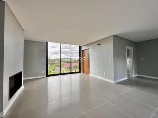 Sala de estar ampla com piso de porcelanato e grande janela.