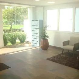 Sala de estar com grandes janelas e piso claro.