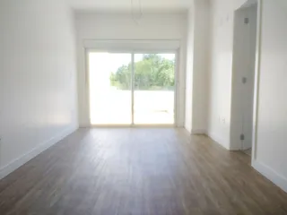 A sala de estar é um ambiente claro com grande porta de vidro voltada para o exterior.