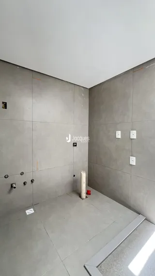 Foto de um interior com paredes cinzas e piso de concreto.