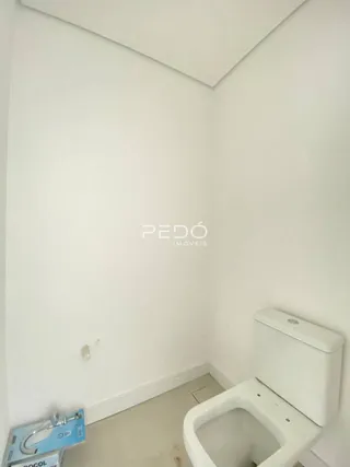 Foto de uma parede branca com um vaso sanitário em um imóvel.